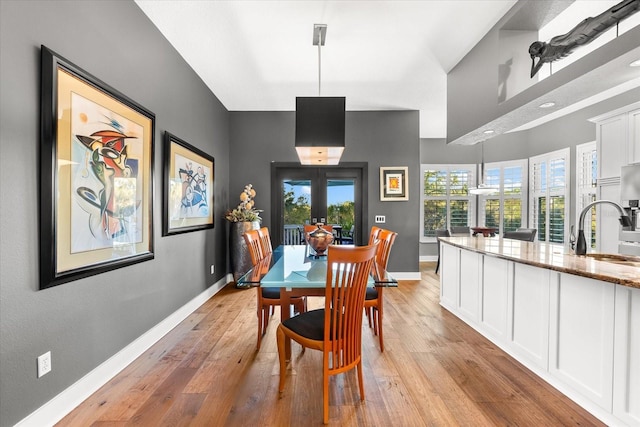 dining area featuring light wood-type flooring and baseboards