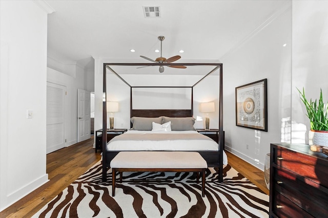 bedroom with recessed lighting, visible vents, wood finished floors, and ornamental molding