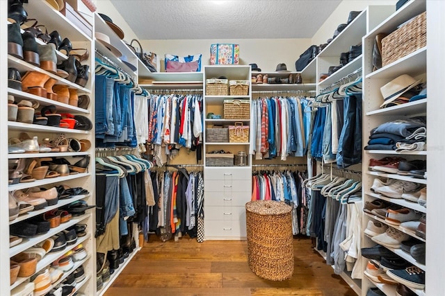 walk in closet with wood finished floors