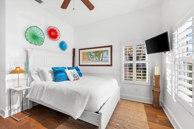 bedroom featuring ceiling fan, baseboards, and wood finished floors