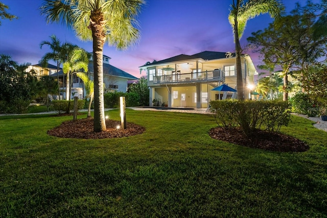 view of front of property featuring a front lawn and a balcony