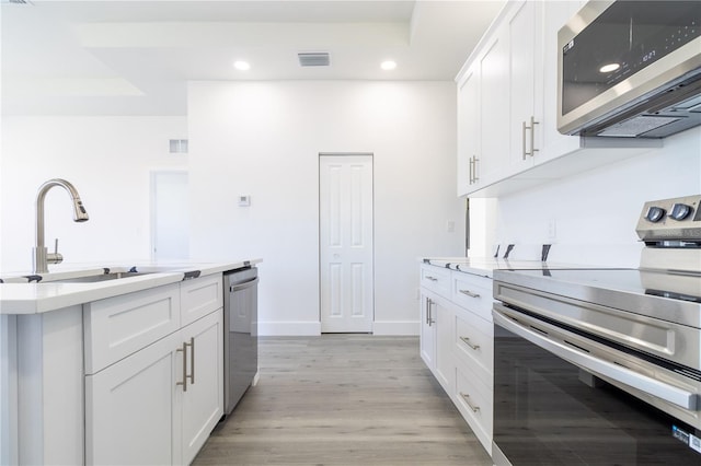 kitchen featuring appliances with stainless steel finishes, sink, and white cabinets