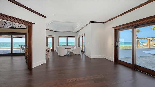 empty room with a water view, baseboards, ornamental molding, and wood finished floors