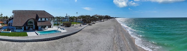 exterior space featuring a water view and a beach view