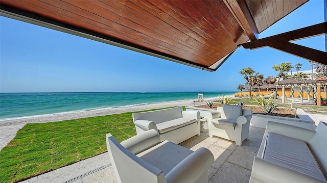 view of patio with an outdoor hangout area, a beach view, and a water view