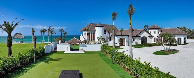 view of property's community with a water view, driveway, and a yard