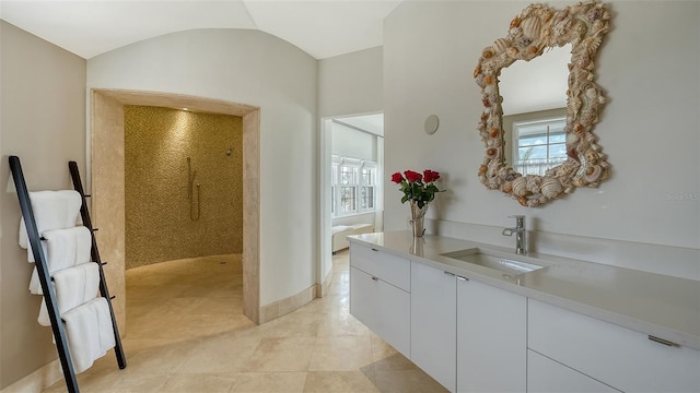 bathroom featuring baseboards, lofted ceiling, tile patterned flooring, walk in shower, and vanity