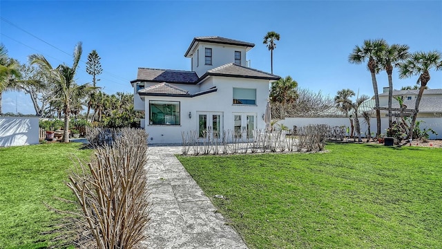 view of front of home featuring stucco siding, a front lawn, and french doors