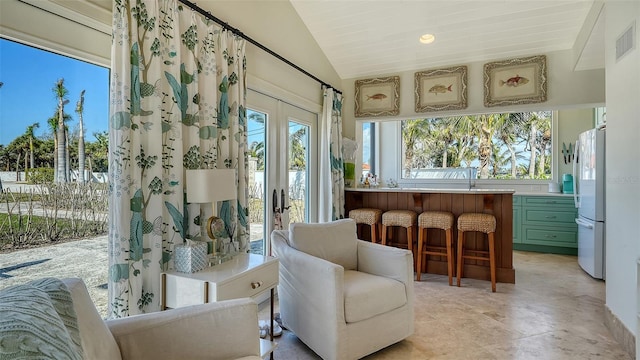 sunroom featuring lofted ceiling, french doors, and visible vents