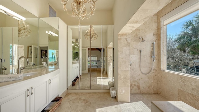 full bathroom featuring a notable chandelier, two vanities, visible vents, a sink, and walk in shower