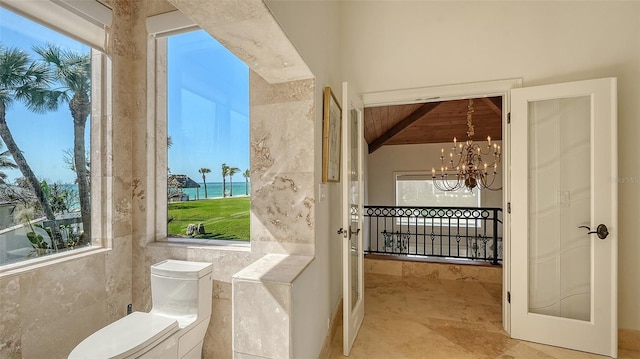 bathroom with toilet, wood ceiling, tile walls, beam ceiling, and an inviting chandelier