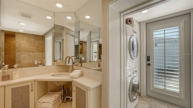 bathroom with recessed lighting, stacked washer and clothes dryer, visible vents, and vanity