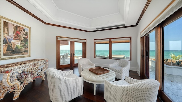 sitting room with french doors, a raised ceiling, and crown molding