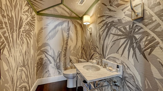 bathroom featuring visible vents, toilet, lofted ceiling, wood finished floors, and vanity