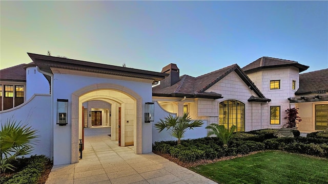 view of front of property with a chimney and stucco siding