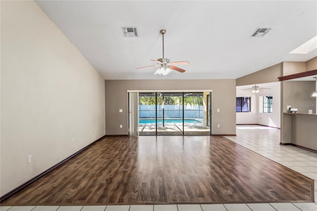 13112 Groveland St, Spring Hill, FL 34609 - unfurnished living room featuring lofted ceiling with skylight, wood finished floors, and visible vents