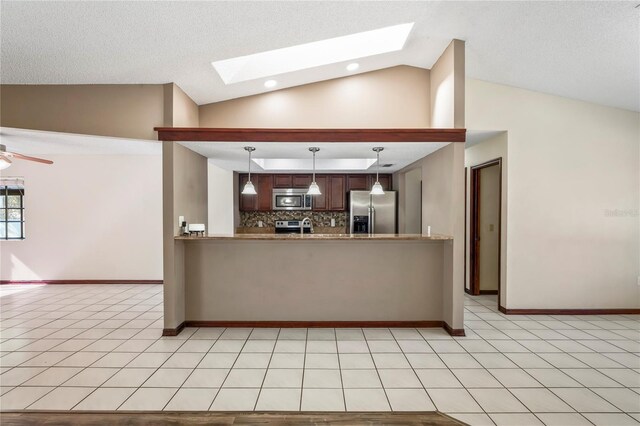 13112 Groveland St, Spring Hill, FL 34609 - kitchen featuring light tile patterned floors, vaulted ceiling with skylight, a ceiling fan, appliances with stainless steel finishes, and decorative backsplash