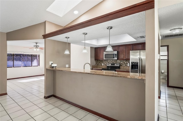 13112 Groveland St, Spring Hill, FL 34609 - kitchen featuring light tile patterned flooring, stainless steel appliances, backsplash, lofted ceiling with skylight, and a raised ceiling