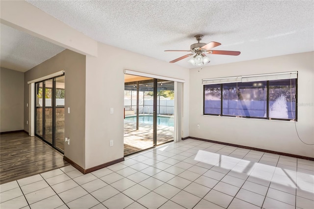 13112 Groveland St, Spring Hill, FL 34609 - unfurnished room featuring ceiling fan, baseboards, a textured ceiling, and light tile patterned flooring