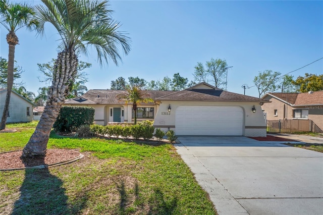 ranch-style home with a garage, brick siding, fence, concrete driveway, and stucco siding