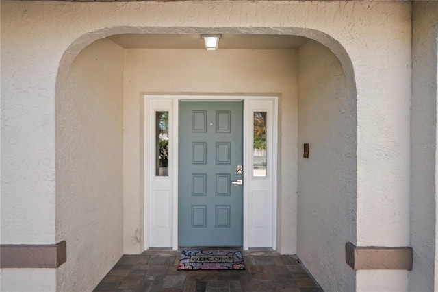 view of exterior entry with stucco siding