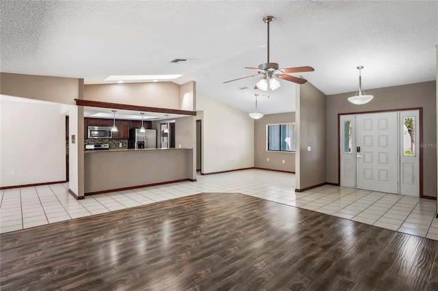 13112 Groveland St, Spring Hill, FL 34609 - foyer featuring visible vents, light tile patterned flooring, vaulted ceiling, a textured ceiling, and ceiling fan