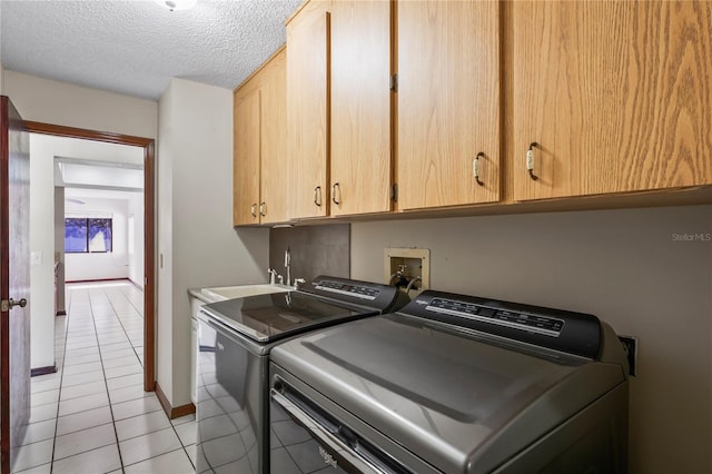 13112 Groveland St, Spring Hill, FL 34609 - washroom with light tile patterned floors, a textured ceiling, a sink, cabinet space, and washing machine and clothes dryer