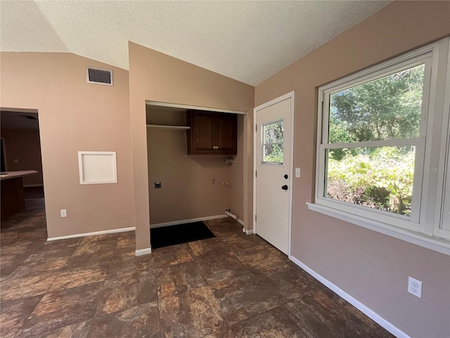 clothes washing area featuring visible vents, a textured ceiling, and baseboards