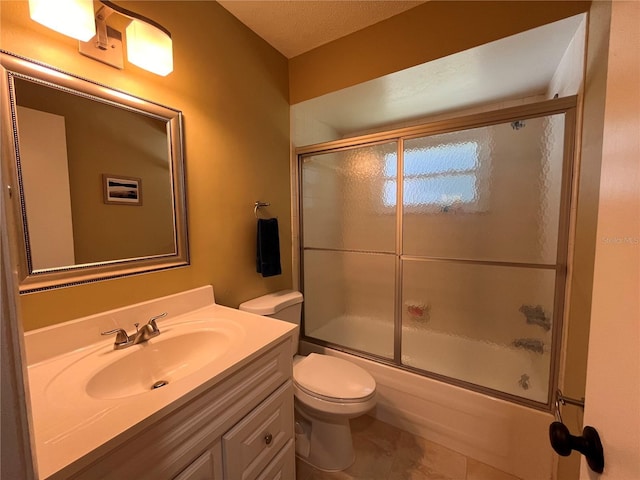 bathroom featuring toilet, shower / bath combination with glass door, vanity, and tile patterned floors