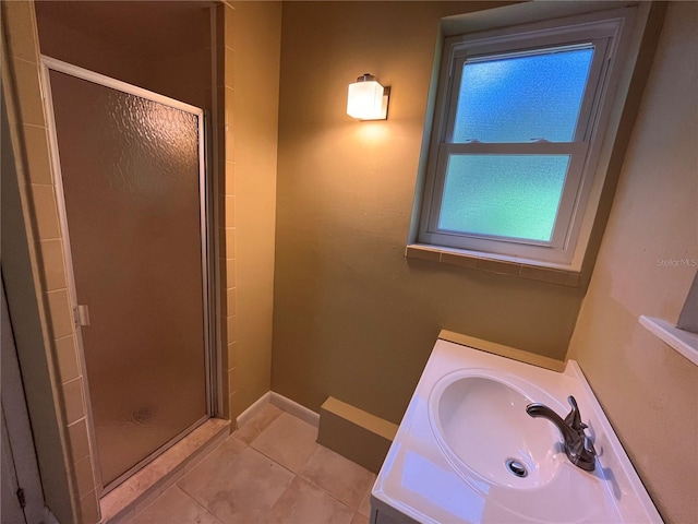 bathroom featuring a stall shower, vanity, baseboards, and tile patterned floors