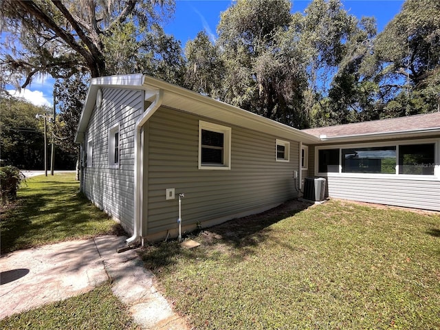 view of home's exterior featuring a lawn and central AC unit