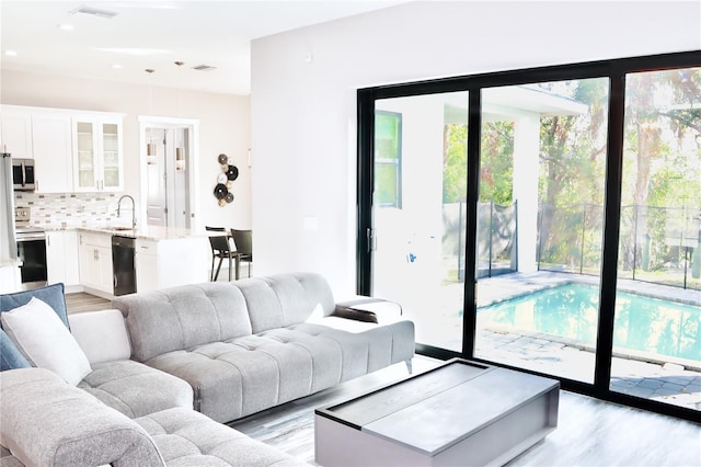 living room featuring light wood finished floors, visible vents, and recessed lighting