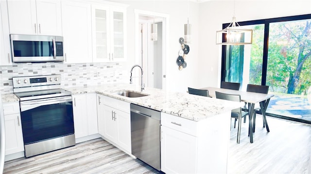 kitchen featuring glass insert cabinets, white cabinetry, and appliances with stainless steel finishes