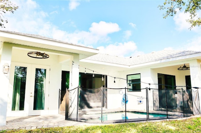 rear view of house featuring french doors, a patio, and stucco siding