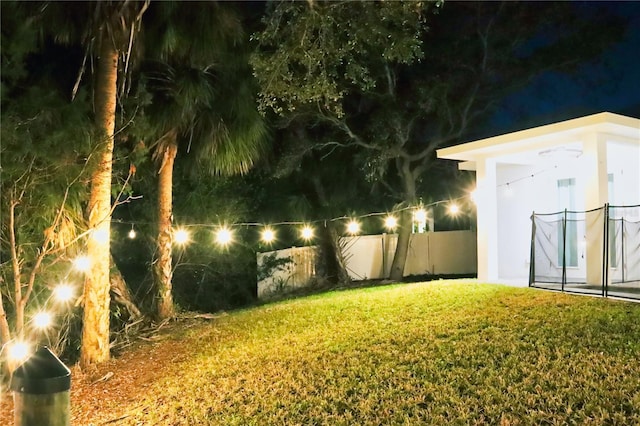 yard at night featuring fence