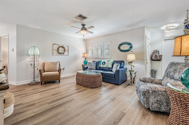 living room with visible vents, ceiling fan, light wood-style flooring, and baseboards