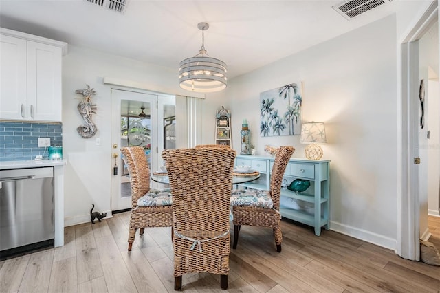 dining room with a chandelier, light wood-type flooring, and visible vents