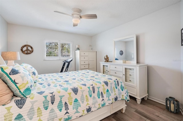 bedroom featuring dark wood-style floors, ceiling fan, and baseboards