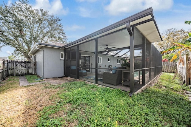 back of property with a fenced backyard, ceiling fan, and a lawn