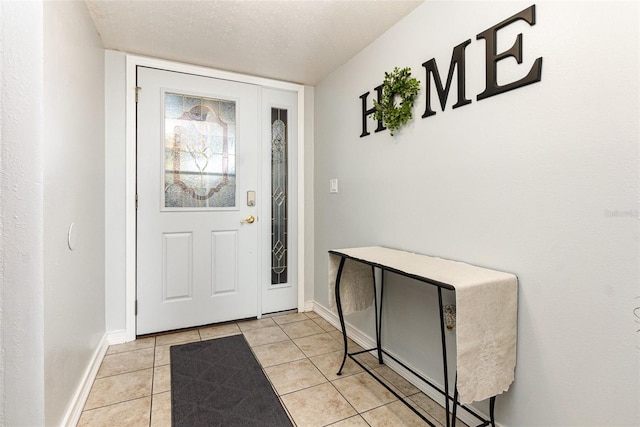 entryway with a textured ceiling and light tile patterned flooring