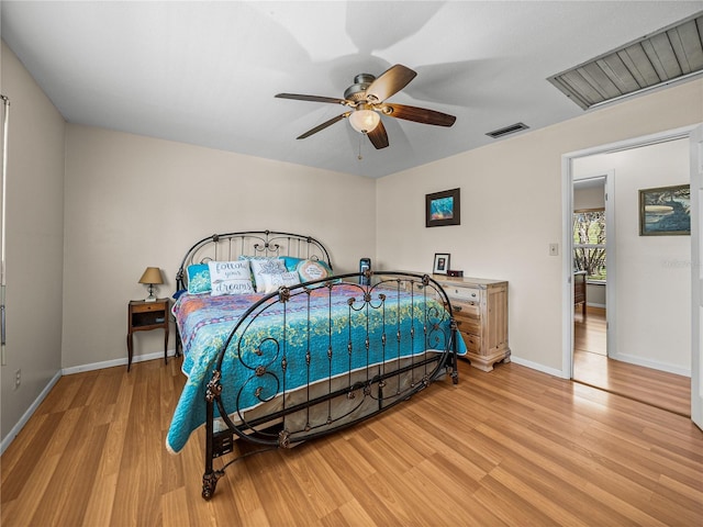 bedroom with light wood-style floors, visible vents, ceiling fan, and baseboards