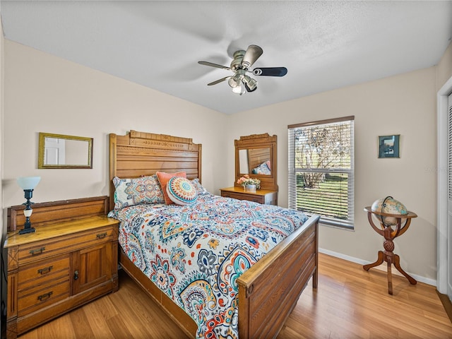 bedroom featuring light wood-style floors, ceiling fan, and baseboards