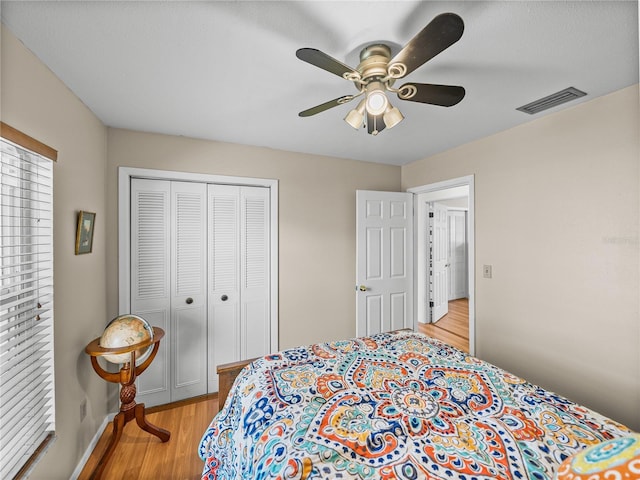 bedroom featuring baseboards, visible vents, ceiling fan, light wood-type flooring, and a closet