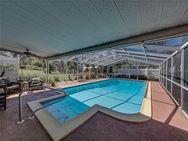 view of pool with a fenced in pool, glass enclosure, a fenced backyard, ceiling fan, and a patio area