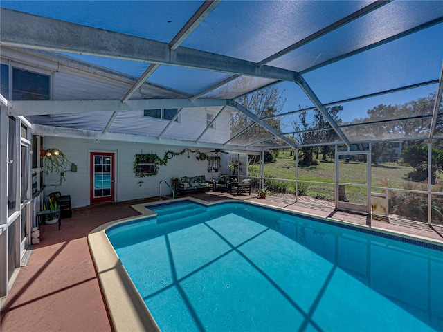 outdoor pool featuring glass enclosure and a patio area