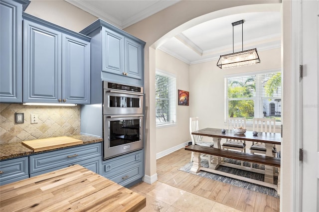 4301 W San Luis St, Tampa, FL 33629 - kitchen featuring arched walkways, double oven, blue cabinetry, and decorative light fixtures