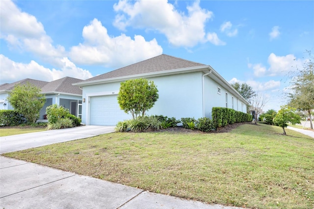 view of side of property featuring a garage and a lawn