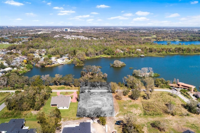 birds eye view of property featuring a water view and a wooded view