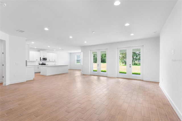 2569 Rogers Rd, Lakeland, FL 33812 - unfurnished living room featuring light wood-style floors, recessed lighting, and french doors