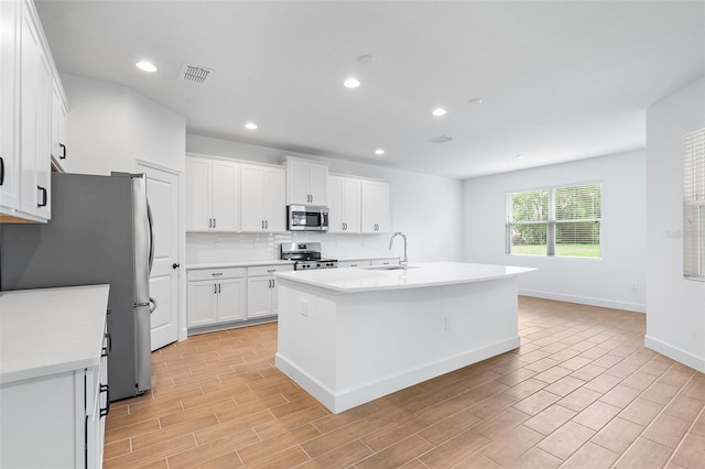 2569 Rogers Rd, Lakeland, FL 33812 - kitchen featuring appliances with stainless steel finishes, white cabinets, decorative backsplash, light countertops, and light wood-style floors